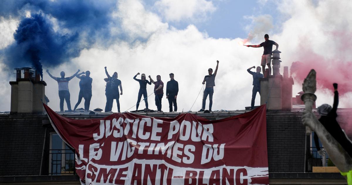 Des militants sur les toits de la place de la République avec la banderole et des fumigènes le 13 juin 2020